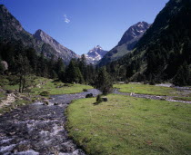 Vallee de Lutour.  View south over lower valley with central snow covered peak of Pic de Labas 2927 m / 9586 ft south of Cauterets.  Sparkling river and trees.