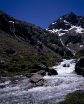 Vallee du Lutour.  Upper valley view south towards snow covered peak of Pic de Labas 2927 m / 9586 ft with stream Gave d Estrom Soubiran in foreground.