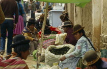 Men and women with coca leaves for sale at marketAmerican Bolivian Female Woman Girl Lady Hispanic Latin America Latino Male Man Guy South America