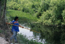 Independent Seminole Native American man named Bobby fishing with a spear in a canal next to Tamiami HighwayNorth America United States of America American Male Men Guy Motorway One individual Solo...