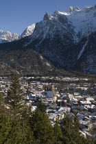 View over Mittenwald town rooftops from surrounding hillside with snow covered mountains behindLandscape Winter Mountains Geography Bayern Deutschland European Scenic Western Europe