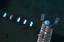 Solitary figure lounging on beach tub in Sorrento Harbour with deck on leftHolidays Italy Leisure Beaches European Italia Italian Resort Sand Sandy Seaside Shore Southern Europe Tourism