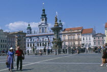 Czech Republic, South Bohemia, Ceske Budejovice, Town Square with Samson fountain and Town Hall behind people sitting and walking.