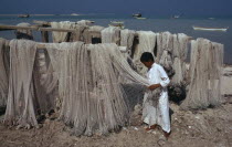 Fisherman with nets drying beside the seaMiddle East One individual Solo Lone Solitary Qatari