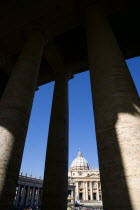 Vatican City The Basilica of St Peter and the square or Piazza San Pietro with tourists seen through the columns of BerniniEuropean Italia Italian Roma Southern Europe Catholic Principality Citta del...