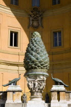 Vatican City Museums The Cortille della Pigna a huge bronze pine cone from a Roman fountain in a niche below the Papal heraldic crest in a niche by Pirro Ligorio on the Belvedere Palace European Ital...