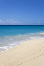 South Glossy Beach in Glossy Bay with waves breaking on the shoreline of the turqoise sea and yachts on the horizonBeaches Resort Sand Sandy Scenic Seaside Shore Tourism West Indies Caribbean Souther...