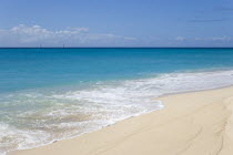 South Glossy Beach in Glossy Bay with waves breaking on the shoreline of the turqoise sea and yachts on the horizonBeaches Resort Sand Sandy Scenic Seaside Shore Tourism West Indies Caribbean Souther...