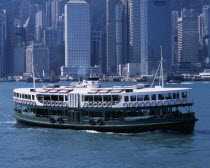 Star Ferry crossing Victoria Harbour  high rise city buildings part seen behind.Asia Asian Chinese Chungkuo Jhonggu Zhonggu