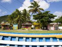 Colourful fruit and vegetable market stalls in Mulzac Square with a fishing boat in the foregroundCaribbean West Indies Windward Islands Colorful