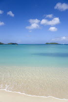 The calm clear blue water breaking on Paradise Beach in LEsterre Bay with The Sister Rocks and Mabouya Island in the distanceCaribbean Grenadian Greneda West Indies Grenada Beaches Resort Sand Sandy...