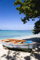 The calm clear blue water breaking on Paradise Beach in LEsterre Bay with Sandy Island in the distance. A small fishing boat sits on the beach out of the waterCaribbean Grenadian Greneda West Indies...