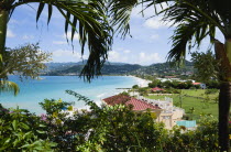 Gentle waves of the aquamarine sea breaking on the two mile stretch of the white sand Grand Anse Beach seen through palm treesCaribbean Grenadian Greneda West Indies Grenada 2 Beaches Resort Sandy Sc...