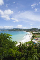 Gentle waves of the aquamarine sea breaking on the two mile stretch of the white sand Grand Anse Beach with the capital city of St Georges in the distanceCaribbean Grenadian Greneda West Indies Grena...