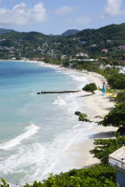 Waves of the aquamarine sea breaking on the two mile stretch of Grand Anse Beach with people on the white sandy beachCaribbean Grenadian Greneda West Indies Grenada 2 Beaches Holidaymakers Resort Sce...