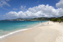 Waves of the aquamarine sea breaking on the two mile stretch of Grand Anse Beach with people on the white sandy beach and the capital city of St Georges in the distanceCaribbean Grenadian Greneda Wes...