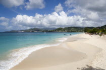 Waves of the aquamarine sea breaking on the two mile stretch of Grand Anse Beach with people on the white sandy beach and the capital city of St Georges in the distanceCaribbean Grenadian Greneda Wes...