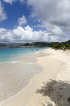 Waves of the aquamarine sea breaking on the two mile stretch of Grand Anse Beach with people on the white sandy beach and the capital city of St Georges in the distanceCaribbean Grenadian Greneda Wes...