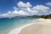 Waves of the aquamarine sea breaking on the two mile stretch of Grand Anse Beach with people on the white sandy beach and the capital city of St Georges in the distanceCaribbean Grenadian Greneda Wes...