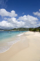 Waves of the aquamarine sea breaking on the two mile stretch of Grand Anse Beach with people on the white sandy beach and the capital city of St Georges in the distanceCaribbean Grenadian Greneda Wes...