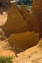 Colorado Provencal.  Cheminee de Fee or Fairy Chimneys.   A tourist standing at park viewpoint surrounded by peaks and gullys of eroded ochre rock.  Ochre Trail European French Western Europe Sightse...