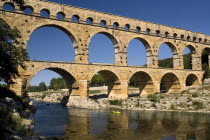 Pont du Gard.  View from west side of the Roman aqueduct in glowing evening light with passing canoe and reflection in the water below.Bridge European French Western Europe Warm Light