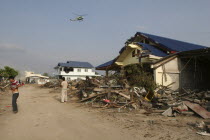 Tsunami. Locals look up at a helicopter which is surveying the damage caused by the tsunami  nothing is left standing in the village 2500 people are pressumed dead 125kms north of Phuket on the 2nd Ja...