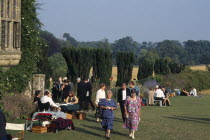 Opera attendees enjoying picnics in the gardens during performance intervalEuropean Great Britain Northern Europe Public Presentation UK United Kingdom British Isles