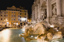 The 1762 Trevi Fountain by Nicola Salvi illuminated at night with tourists in the Piazza Di Trevi with tourists in the Piazza di TreviEuropean Italia Italian Roma Southern Europe Holidaymakers Nite T...