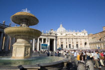 Vatican City Tourists in St Peters Square for the wednesday Papal Audience in front of the Basilica with a water fountain in the foregroundEuropean Italia Italian Roma Southern Europe Catholic Princi...