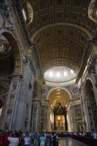 Vatican City Tourists in the main nave of St Peters Basilica showing the ceiling and the Baldacchino an elaborate Baroque canopy by Bernini under the central domeEuropean Italia Italian Roma Southern...