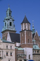 Detail of Wawel Cathedral exterior with clock tower above second tower and series of domed and pointed rooftops. Eastern Europe European Polish Polska Religion Religious Cracow Krakov History