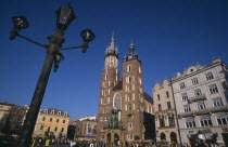 Mariacki Basilica or Church of St Mary.  Gothic  red brick exterior built in the fourteenth century overlooking the main market square with street lamp in foreground.14th c. Cracow Eastern Europe Eur...