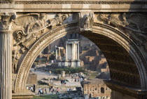 Tourists walking in the Forum with the Temple of The Vestals seen through the Arch of Septimius SeverusEuropean Italia Italian Roma Southern Europe History Holidaymakers Tourism