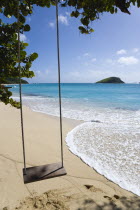 Empty swing hanging from a tree over the beach and breaking waves on Glossy Bay BeachBeaches Resort Sand Sandy Scenic Seaside Shore Tourism West Indies Caribbean Windward Islands Beaches Resort Sand...