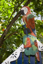 Colourful wooden parrot on the top of a building set amongst trees in CliftonBeaches Resort Sand Sandy Scenic Seaside Shore Tourism West Indies Caribbean Colorful Windward Islands Beaches Resort San...