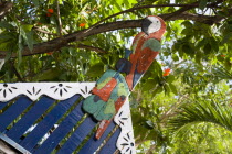 Colourful wooden parrot on the top of a building set amongst trees in CliftonBeaches Resort Sand Sandy Scenic Seaside Shore Tourism West Indies Caribbean Colorful Windward Islands Beaches Resort San...