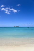 Gentle waves breaking on the shoreline of Paradise Beach in L Esterre Bay with Sandy Island sand bar on the horizonBeaches Resort Sand Sandy Scenic Seaside Shore Tourism West Indies Caribbean Grenadi...