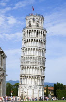 The Campo dei Miracoli or Field of Miracles.Tourists on top of the Leaning Tower or Torre Pendente belltower with others walking around the base under a blue skyEuropean Italia Italian Southern Europ...