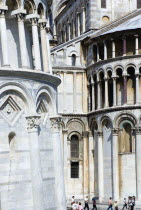 Campo dei Miracoli or Field of Miracles. Detail of the Duomo Cathedral and Leaning Tower or Torre Pendente belltower with tourists walking at the baseEuropean Italia Italian Southern Europe Toscana T...