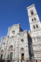 The Neo-Gothic marble west facade of the Cathedral of Santa Maria del Fiore the Duomo and the Giotto Campanile bell tower at sunset with tourists walking in the square at the frontEuropean Italia Ita...