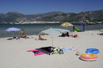 Bathers & sandy beach with St Florent old town in distanceBeaches Resort Seaside Shore Tourism French Western Europe European Sand Sandy Beach Tourism Seaside Shore Tourist Tourists Vacation Sand San...