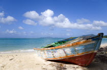 Waves breaking on Paradise Beach at LEsterre Bay with an old fishing boat on the shore and the turqoise sea and Sandy Island sand bar beyond.Beaches Resort Sand Sandy Scenic Seaside Shore Tourism Wes...