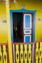 Isla Mujeres  Avenue Juarez. Classic style colored Mexican houses entrance painted yellow  blue and red  Traditional colored Mexican houses shoot on a bright day with blue sky and white cloud.Traditi...