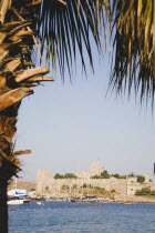 View towards Bodrum castle from palm lined bay.  Formerly Castle of St Peter under Knights Hospitaller of Rhodes  Ottoman since 1522. Turkish Aegean coastmediterraneanresortformerly Halicarnassus...