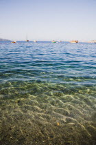 Expanse of clear water with line of Gulet boats at anchor.Turkish Aegean coastmediterraneanresortformerly HalicarnassusHalikarnasregion of CariaDorian Greek occupiedsunlightsunshinesummerse...