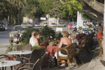 Kos Town.  Harbourside tourists in early summer having a drink at cafe in the shadeGreek IslandsResort Summer Clear Blue Sky early season Aegean DodecaneseDestination Destinations Ellada European Gr...