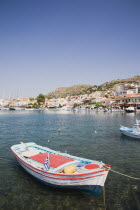 Red  blue and white rowing boat moored in the habour.Greek IslandsResort Summer Clear Blue Sky early season Aegean DodecaneseDestination Destinations Ellada European Greek Southern Europe