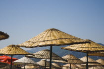 Marmaris on the Turkish Riviera in early summer season.  Tops of parasols for rent on busy beach in morning sun.resortholidayholidaymakersDestinationCrowdedcrowdsun umbrellashadesun loungers...