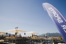 Marmaris on the Turkish Riviera in early Summer season.   Tourists on private jetty with parasols and waiter service to sunbeds.  Part seen blue and white sports flag in foreground.coastcoastalreso...